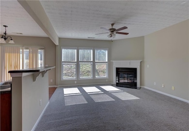 Unfurnished living room featuring carpet, a textur