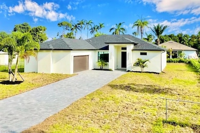 View of front facade featuring a garage, decorative driveway, a front lawn, and stucco siding
