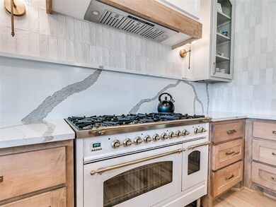 Kitchen with tasteful backsplash, light stone coun