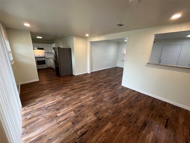 Unfurnished living room featuring dark wood-style floors and recessed lighting