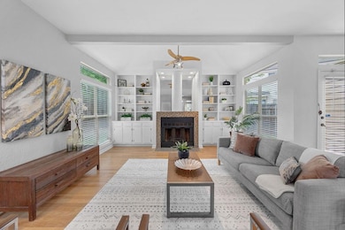 Living area featuring ceiling fan, light wood-sty