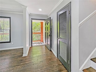 Entrance foyer featuring crown molding, dark wood-style floors, baseboards, and recessed lighting