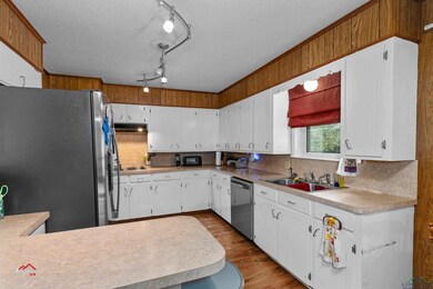 Kitchen featuring sink, white cabinets, light hard