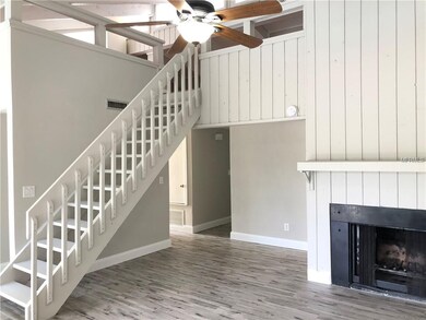 Family room with wood burning fireplace and stairs