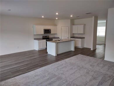 Kitchen with appliances with stainless steel finishes, an island with sink, white cabinets, dark wood-style flooring, and recessed lighting
