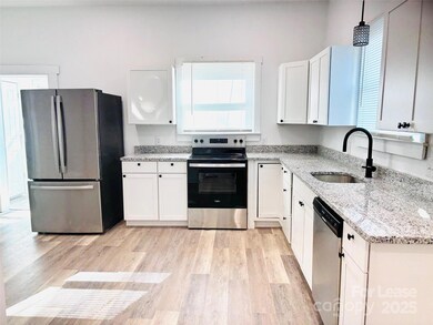 Open concept kitchen with granite countertops and modern appliances.