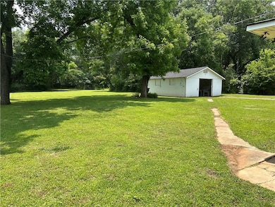View of grassy yard featuring a storage unit