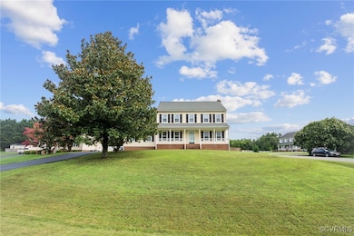 Colonial home featuring covered porch, brick sidin