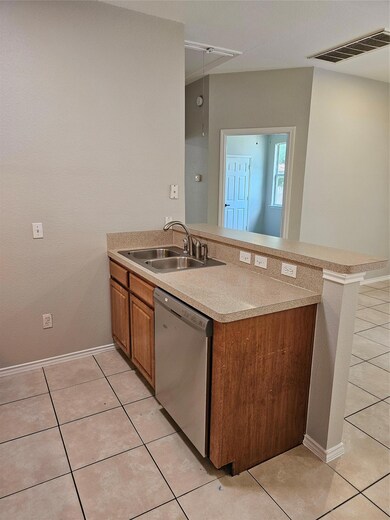 Kitchen featuring dishwasher, a sink, brown cabin