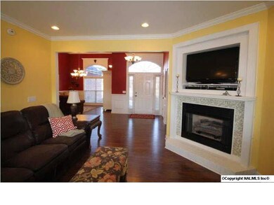 Wonderful open floor plan- this is a view of the Great Room looking toward the front door and the Dining Room. The gas log fireplace has beautiful glass tile surround and a built-in niche for your TV.