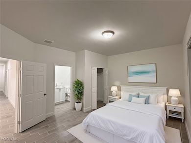 Bedroom featuring a closet, wood tiled floors, and ensuite bathroom