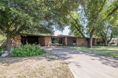House sits on large lot with abundant trees.
