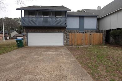 View of front of property featuring a balcony, a g