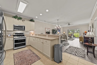 Kitchen featuring appliances with stainless steel finishes, a peninsula, light countertops, light tile patterned floors, and recessed lighting
