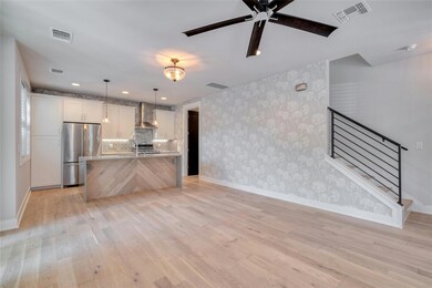Unfurnished living room featuring wallpapered wal