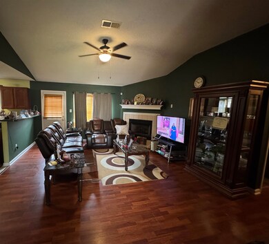 Living area with a ceiling fan, a tiled fireplace,