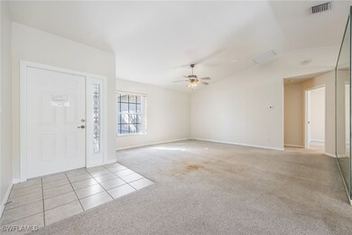 Carpeted foyer entrance featuring ceiling fan