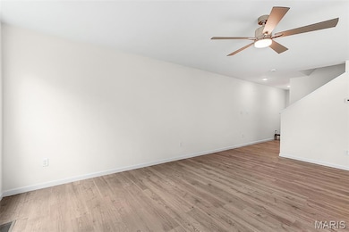 Empty room with light wood-style flooring and ceiling fan