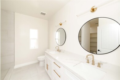 Bathroom featuring double vanity and toilet