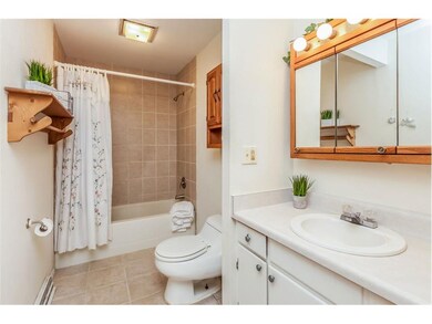 Remodeled bath with tiled shower and tiled floor.
