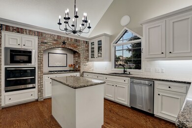 Kitchen has an island and lovely light fixture