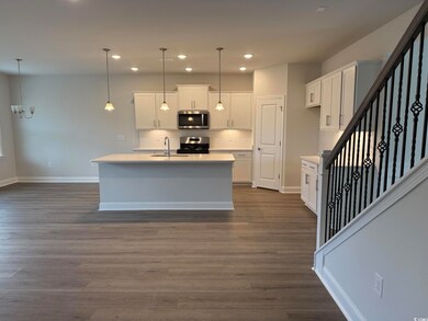 Kitchen with a kitchen island with sink, hanging l