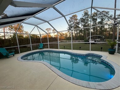Pool at dusk featuring a yard, a lanai, and a pati
