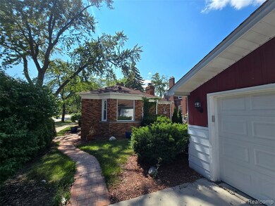 View of side of property featuring brick siding, a chimney, and a garage