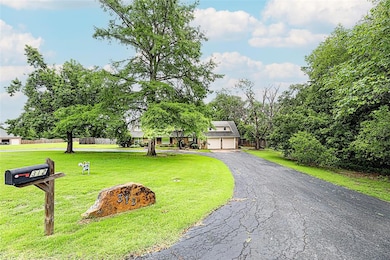 View of front of house featuring asphalt driveway