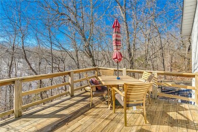 Rear deck overlooking tree covered hills and bike trail across the way.