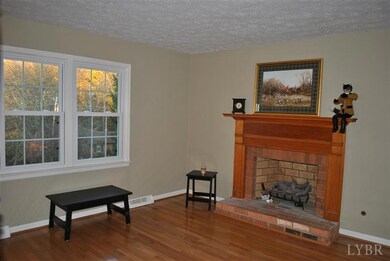 Living room with it's hardwood floors and brick fireplace with gas logs.