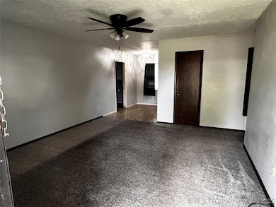 Unfurnished room featuring ceiling fan, a textured