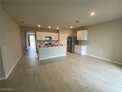Kitchen with white cabinets, a kitchen island with