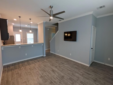 Unfurnished living room featuring ornamental molding, ceiling fan, dark wood-style flooring, and recessed lighting