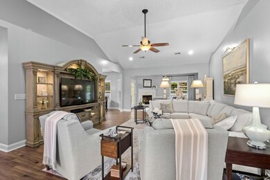 Living room with lofted ceiling, ceiling fan, and 