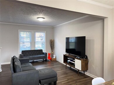 Living room with ornamental molding, a textured ce