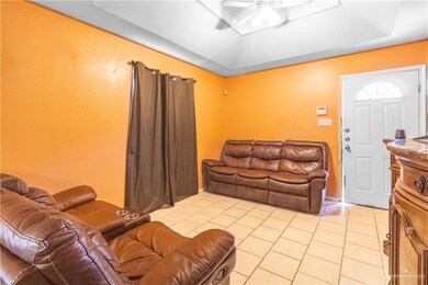 Tiled living room featuring a raised ceiling and ceiling fan