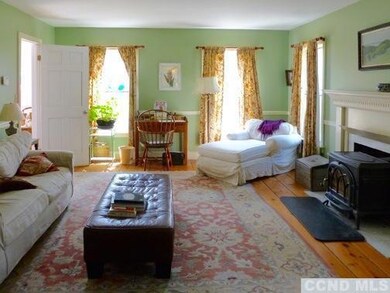Living room with wood burning fireplace & wide boa