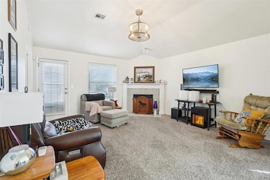 Carpeted living room with a tile fireplace, vaulte