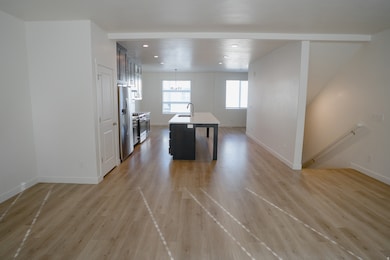Kitchen with decorative light fixtures, an island with sink, open floor plan, light wood-type flooring, and recessed lighting