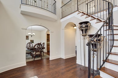 Foyer with baseboards, arched walkways, a chandeli