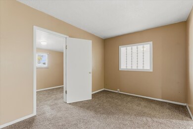 Unfurnished bedroom featuring light carpet and baseboards
