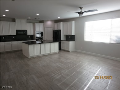 Kitchen featuring dark countertops, backsplash, ba