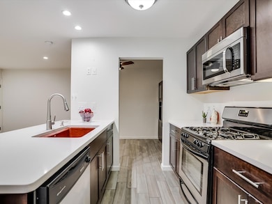 Kitchen featuring light countertops, a sink, wood