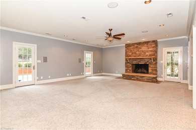 This stupendous great room has carpet flooring, recessed lighting, built-in surround sound speakers, and a ceiling fan/light combination. The main focal point of this space is, without a doubt, the stately wood burning stone fireplace with slate hearth and mantle. This room also features three French doors for access to the outdoor living spaces.