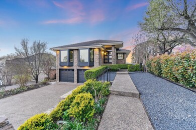 View of front of home featuring a garage and driv