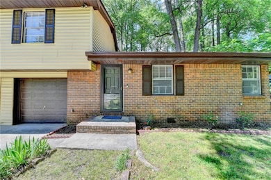 Tri-level home featuring brick siding, an attached