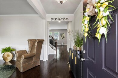 Entryway, dark hardwood flooring, stairway, and custom furnishings.