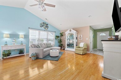 Living room featuring a ceiling fan, light wood-style floors, high vaulted ceiling, and baseboards