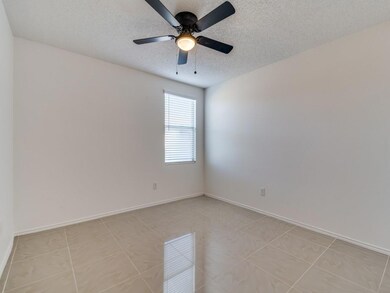 Empty room with light tile patterned floors, a tex